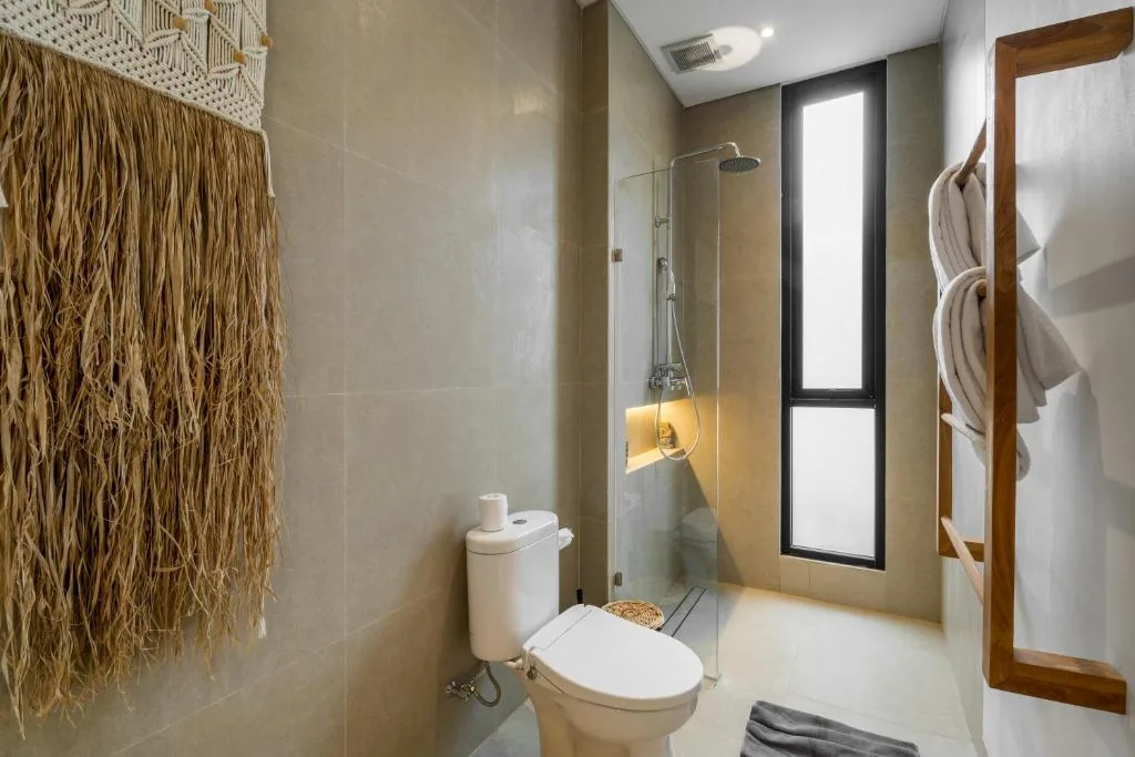 Villa Bahagia bathroom with walk-in shower, wood towel ladder and natural wall decor