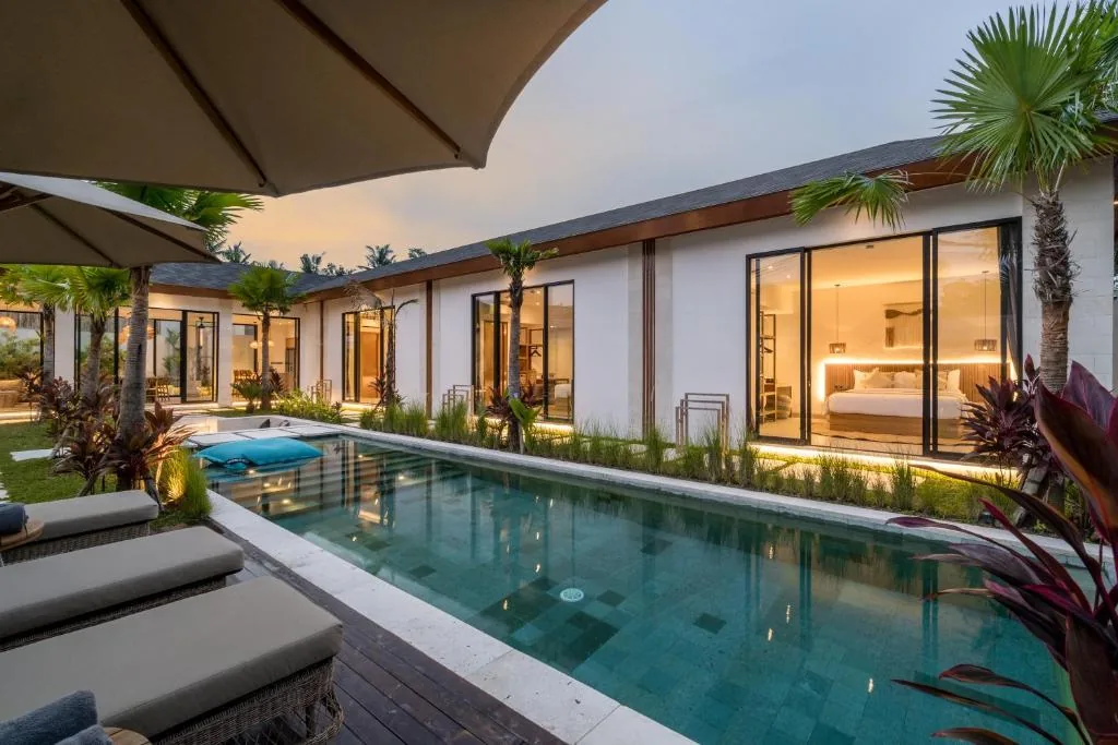 Villa Bahagia exterior with private swimming pool and illuminated bedrooms at dusk