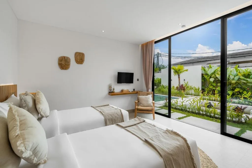 Twin bedroom at Villa Bahagia with pool view and tropical garden